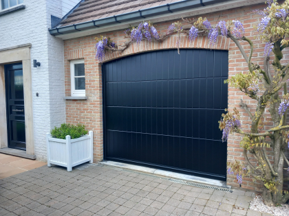 Sectionale garagepoort met sectionale garagepoorten, motor, RAL 9005, V-line verticaal geprofileerd glad, plint, boog